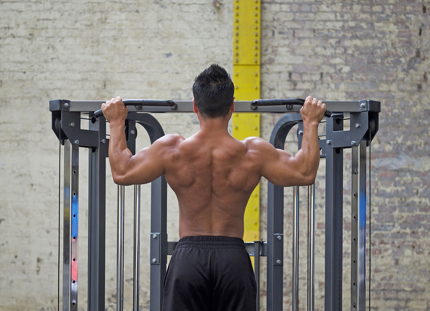 Man doing pull ups with built back muscles