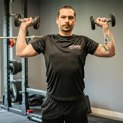 model about to perform a shoulder press with dumbbells.