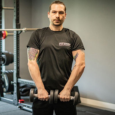 Model holding dumbbells with the ends touching, preparing to do an upright row.