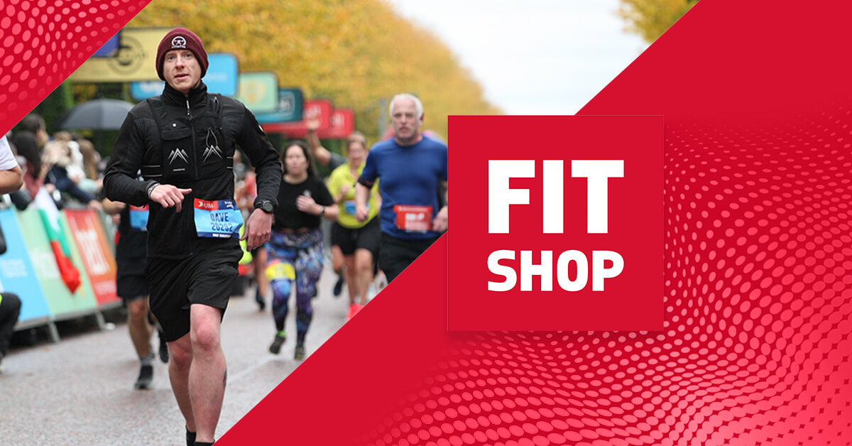 Person running a race with Fitshop branding in the background.